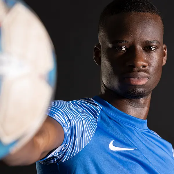 Sportliches Portraitshooting in Zofingen mit Fussballspieler vor dunklem Studiohintergrund und dynamischer Bildwirkung.