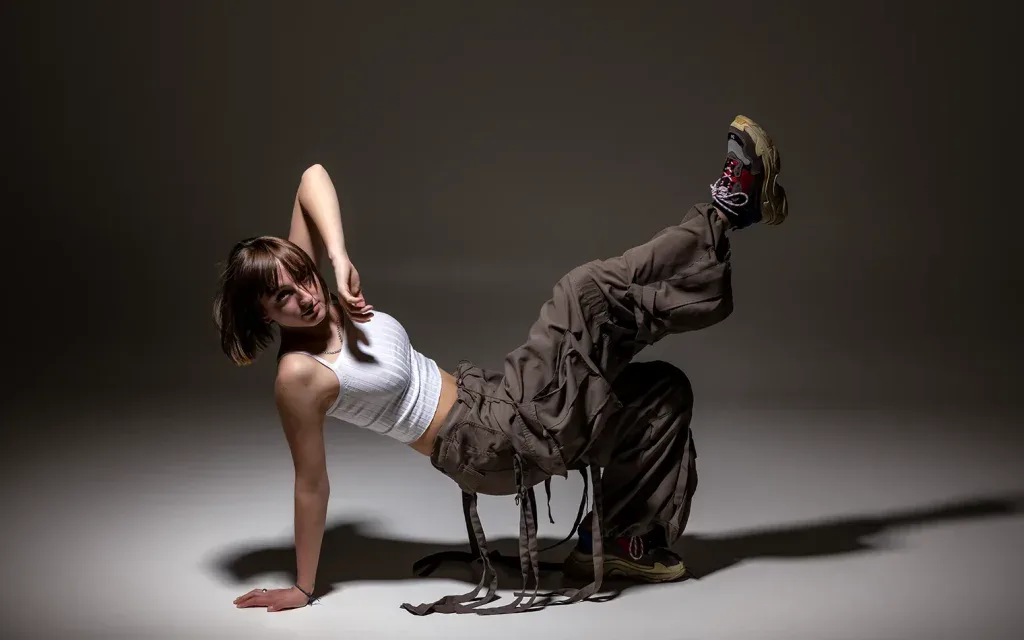 Dynamisches Portraitshooting in Zofingen mit Breakdance-Pose im Studio und markanter Lichtsetzung.