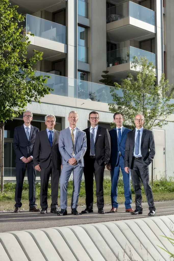 Gruppenfoto eines Management-Teams vor einem modernen Gebäude für Firmenauftritt, Unternehmenswebsite und Pressearbeit.