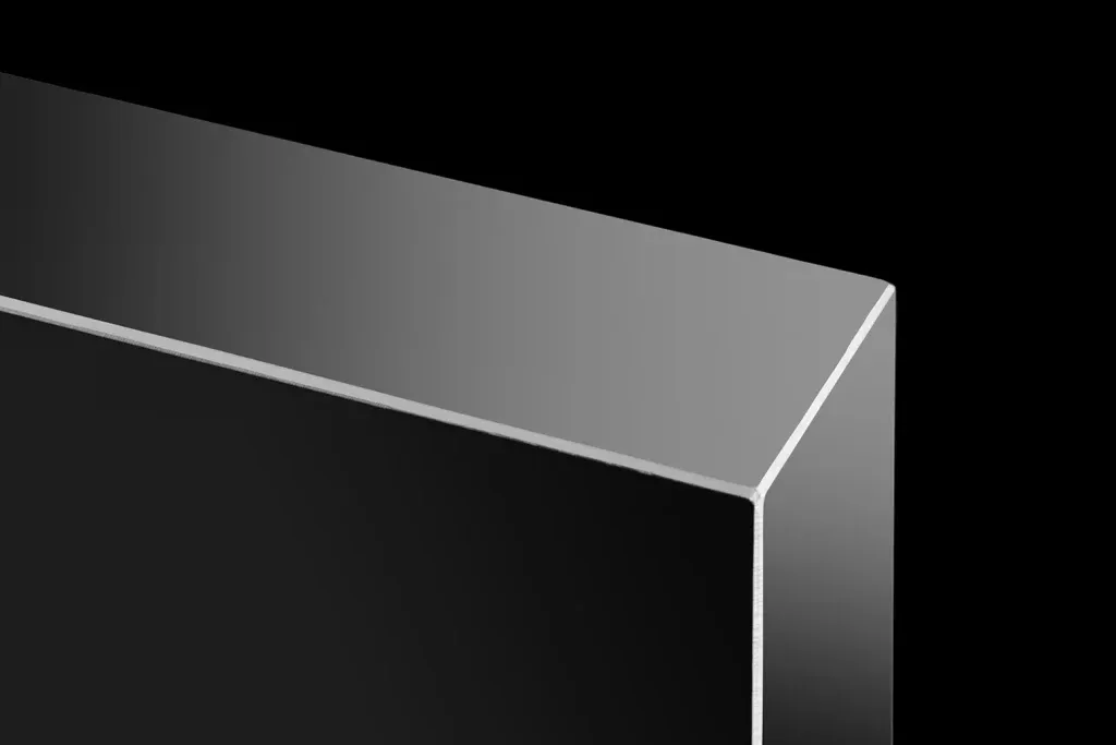 Präzise inszenierte Kante eines silbernen Metallprofils vor schwarzem Hintergrund.