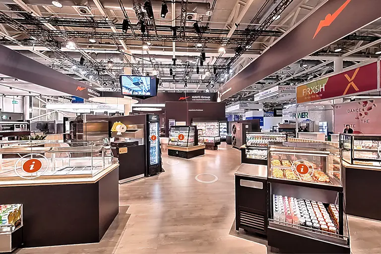 Interaktive 360°-Ansicht eines grossen Messestands mit Verkaufsflächen und Informationspunkten.