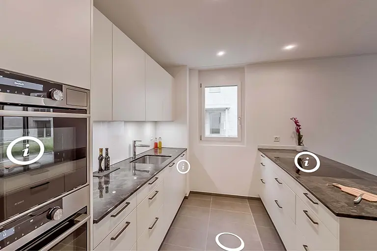 Interaktive 360°-Ansicht einer modernen weissen Küche mit Informationspunkten und Navigation.